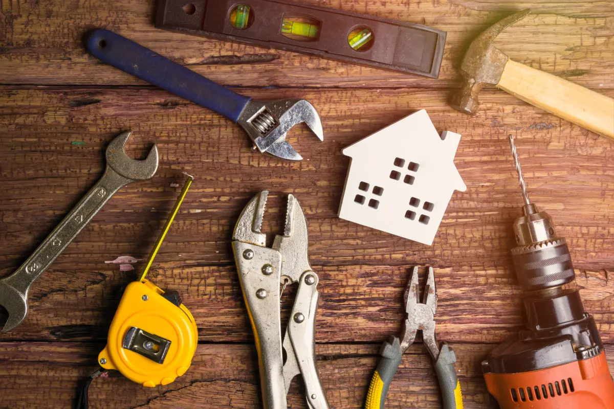Various home improvement tools laid out on a wooden table