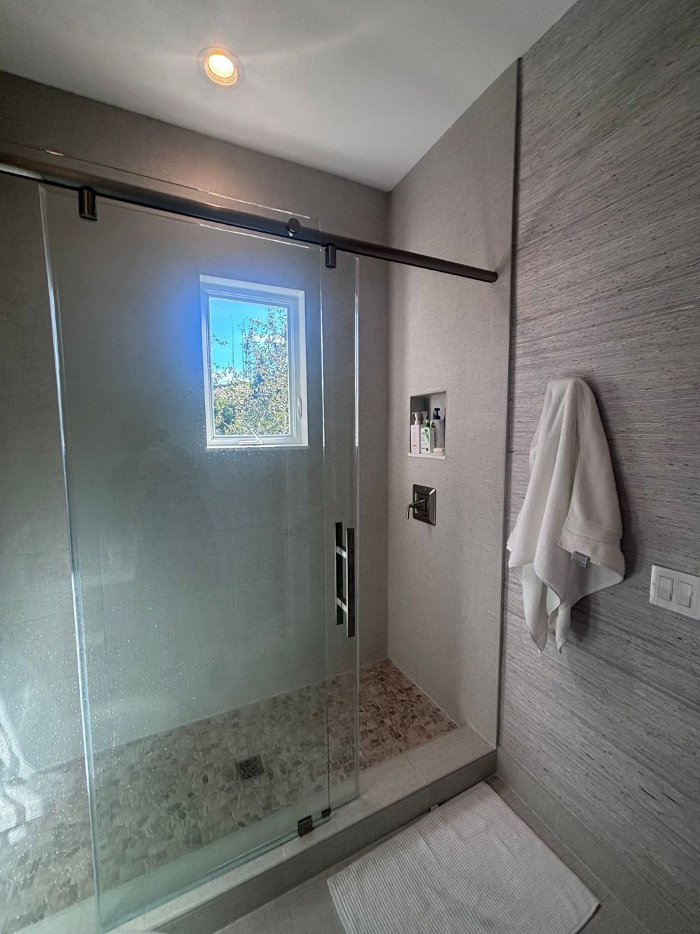 White tile walk-in shower with built-in niche by H&H Signature Renovations