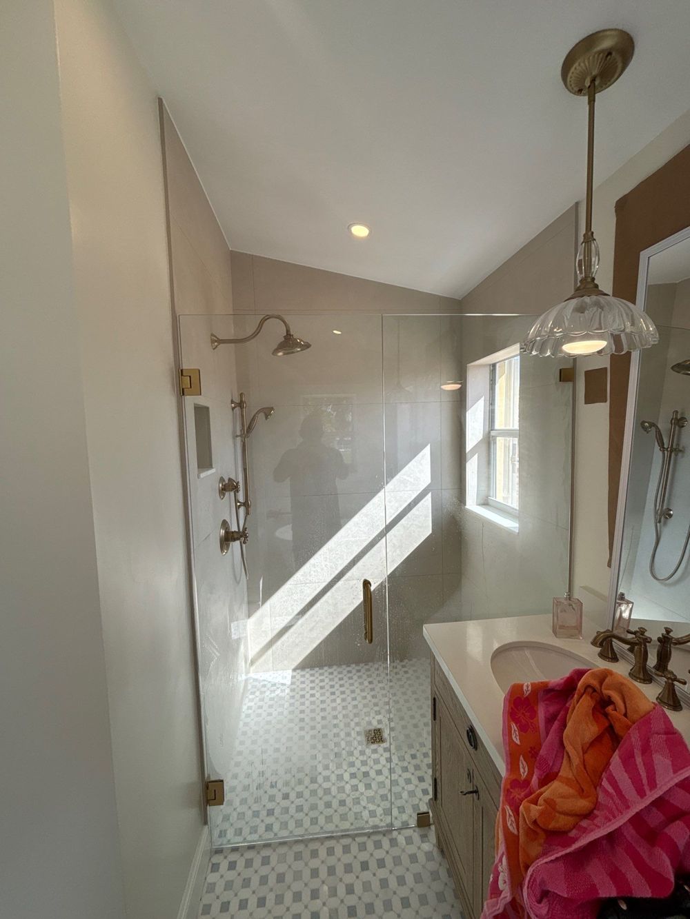 Frameless glass walk-in shower with gold fixtures